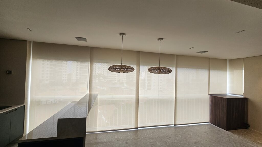 Dining area with roller shades lowered on large windows and two pendant lights