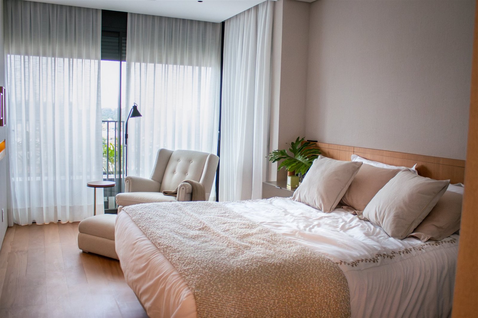 Floor-to-ceiling sheer curtains in a bedroom with an armchair