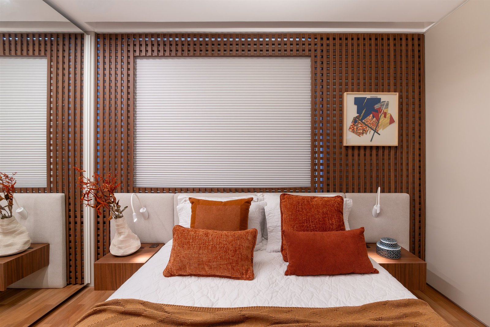Window shade above a bed in a bedroom with a wood slat wall